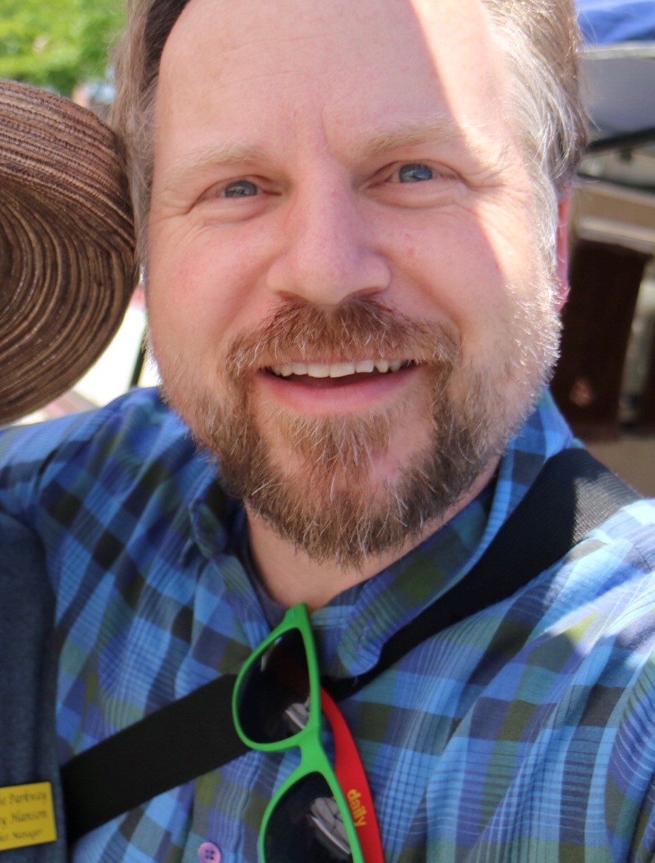 Will Smiles with a beard, wearing a blue plaid shirt