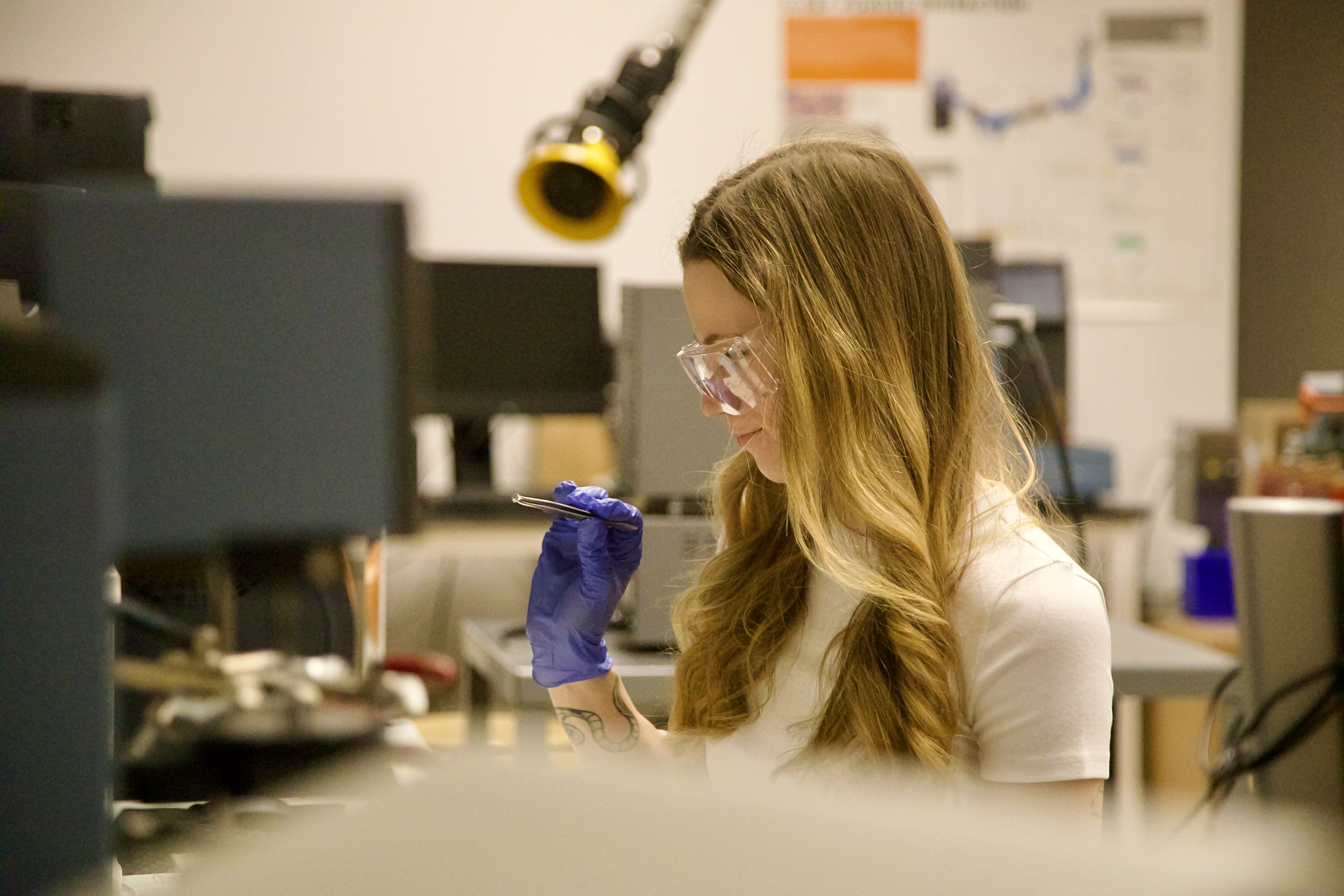 Megan Bellusci examines a sample in a lab as part of her coal fly ash research.
